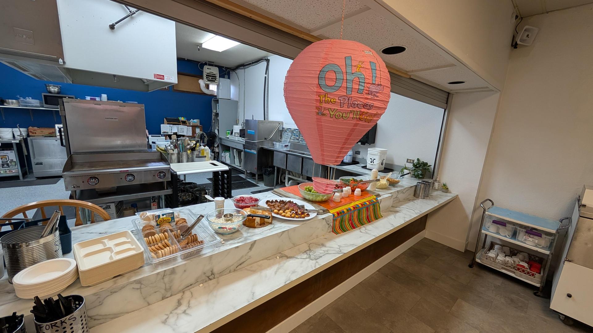 Cafeteria setup featuring a variety of snacks on a marble counter.
