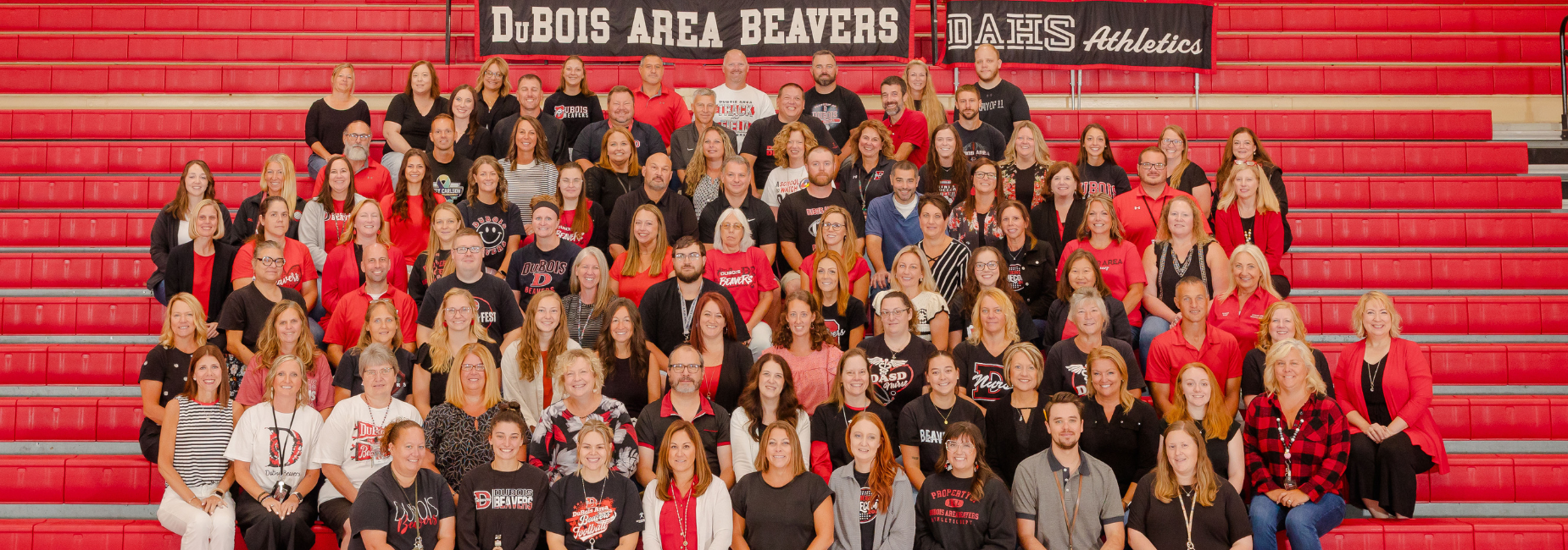 DAMS Faculty and staff dressed in red and black attire in the gymnasium.