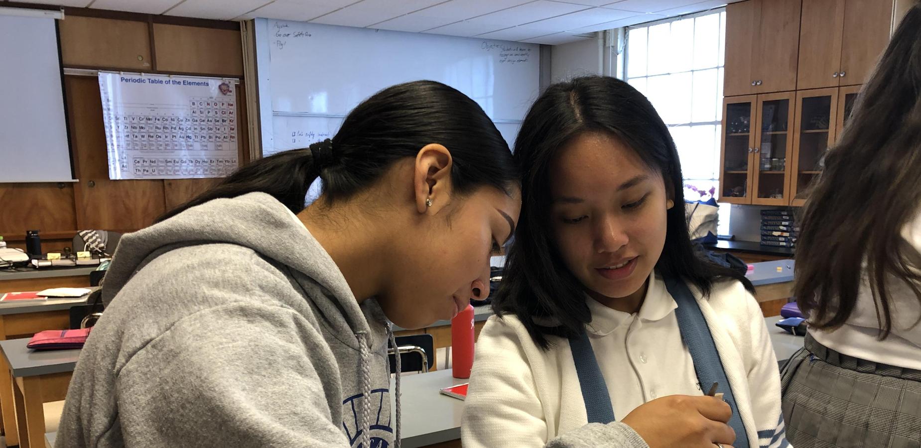 a pair of students measuring as part of a physics lab