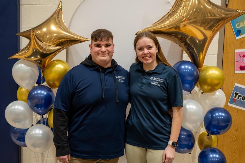 one boy and one girl senior bocce players beside balloons