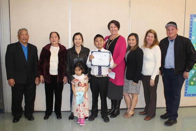 Family members and staff stand with the student being honored.
