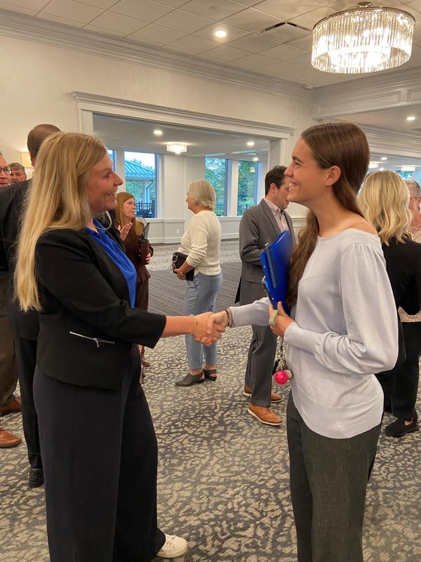 Student shakes hands with a business leader.