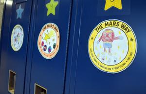 Colorful posters on lockers promoting positive values.