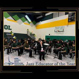 Music teacher Cynthia Needham sits with orchestra in the school gym