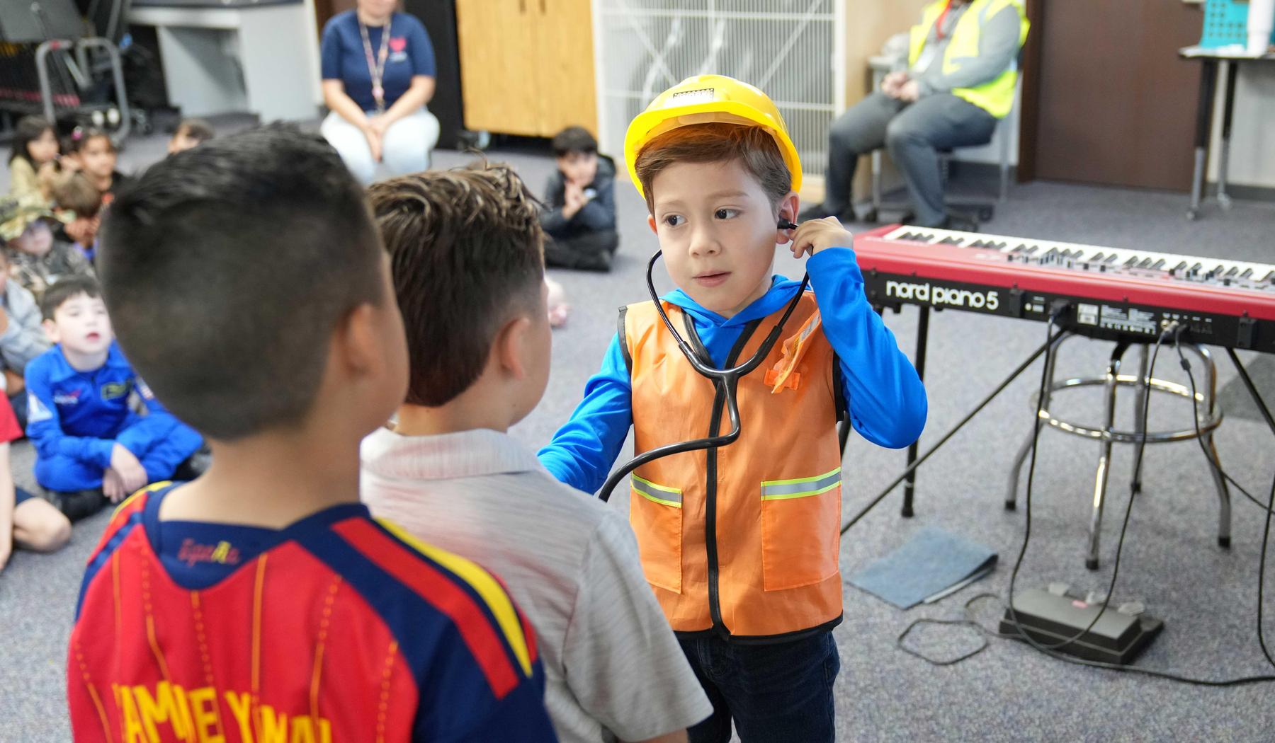 boy dressed as at builder checking heartbeat of a classmate