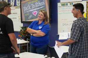 smiling Teacher talking to two former students