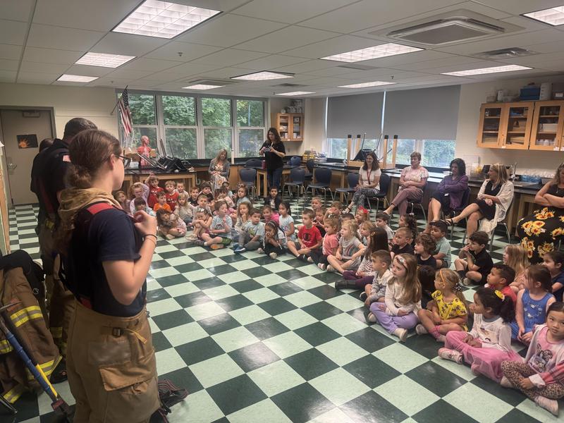 fire fighter talks to students for fire prevention day