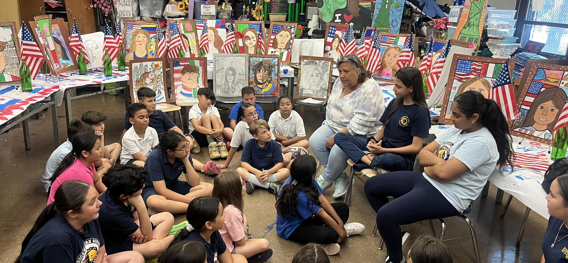 Children gathered in a classroom with artwork and American flags displayed.