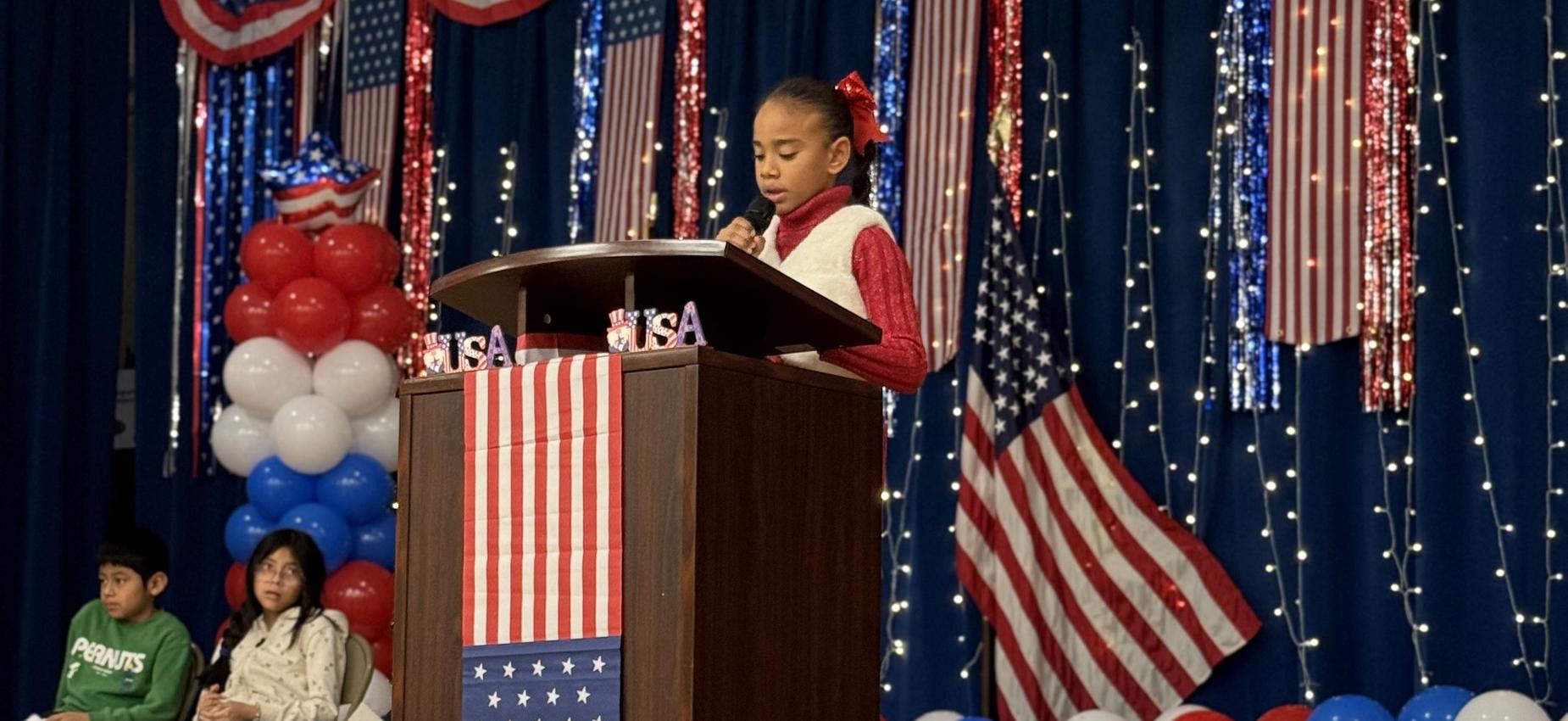 Girl speaking at the podium during student government elections.