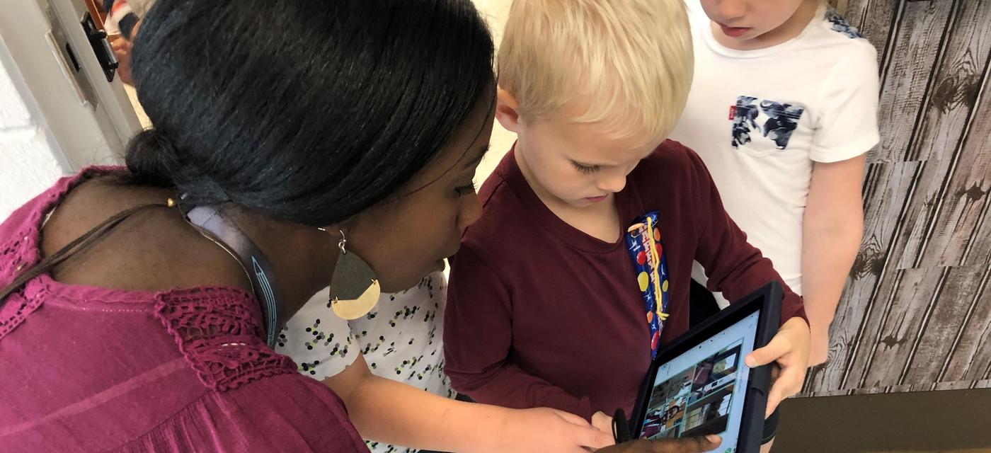 teacher and young students using technology for lesson