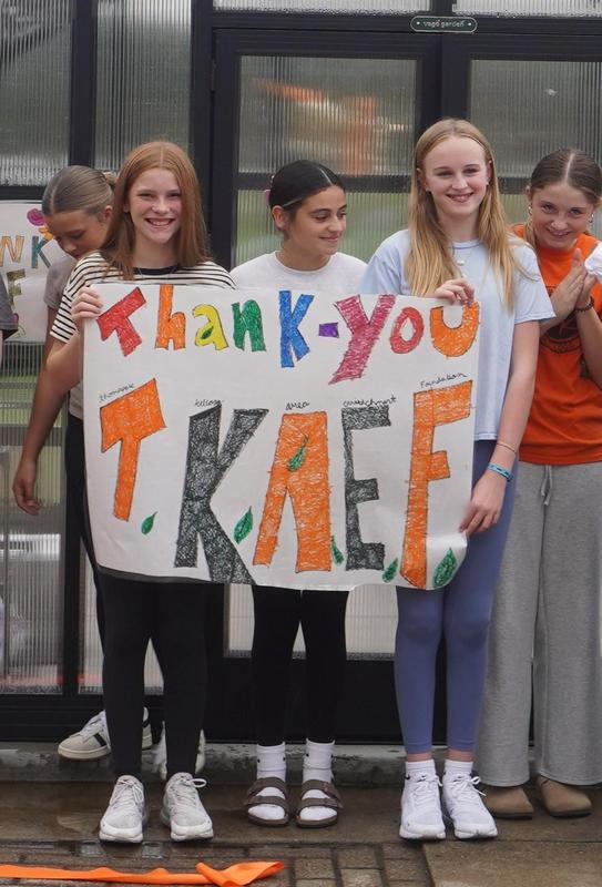Students hold a sign thanking TAEF for supporting the greenhouse project.