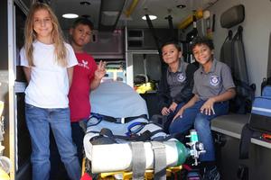 four students touring the inside of an ambulance