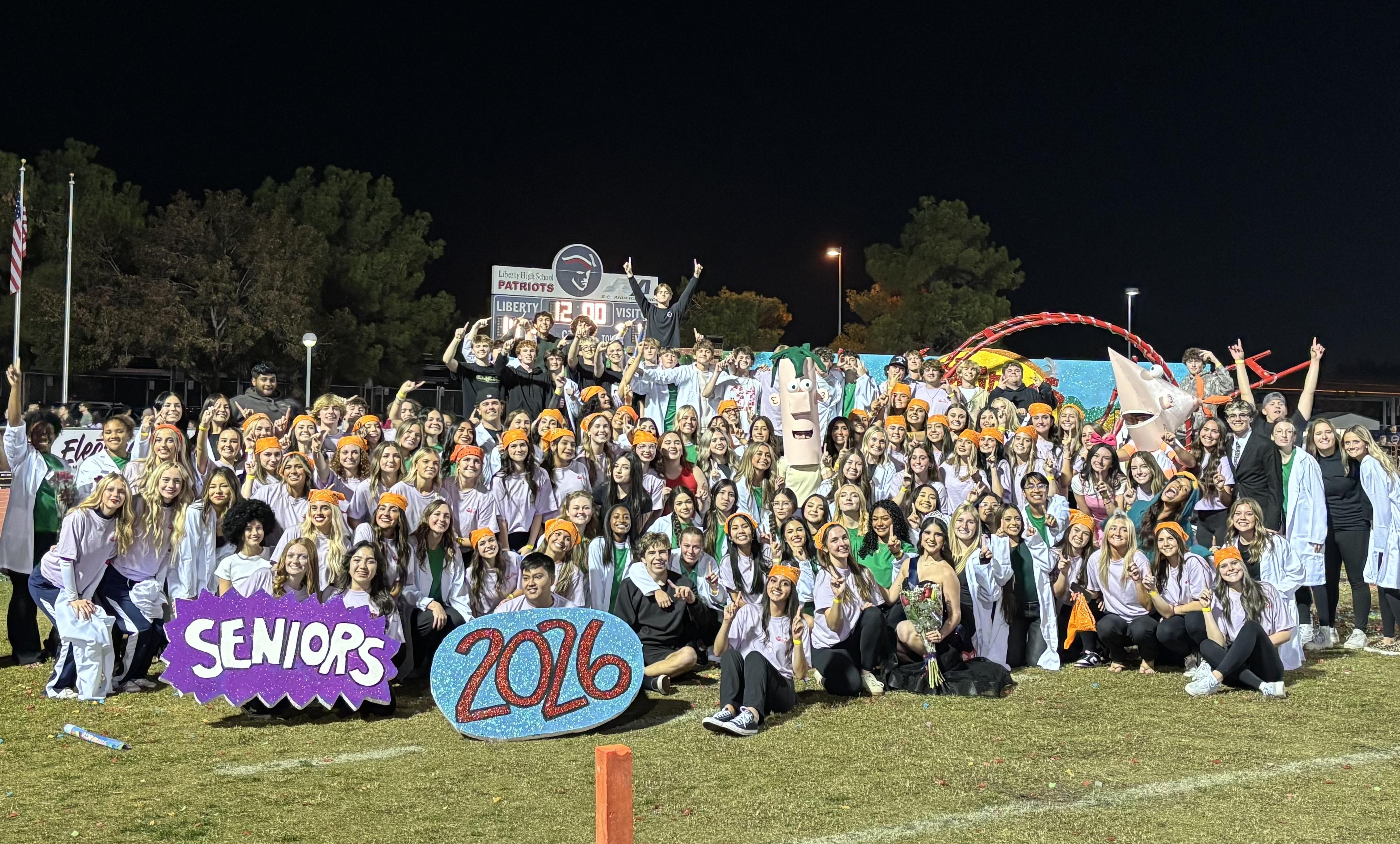 Large group of students celebrating their graduation with decorations at night.