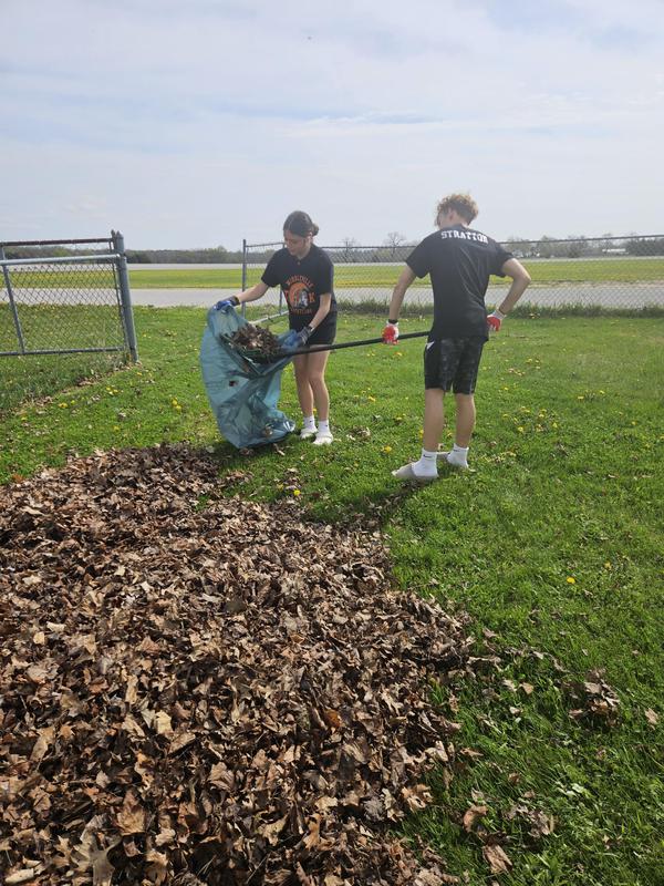 Students rake up leaves at the Barry Expo Center.