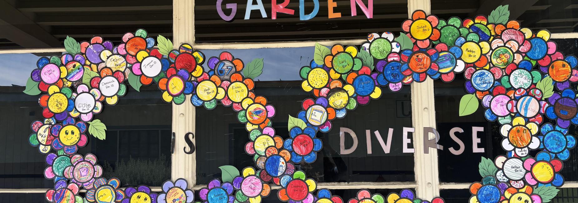 Colorful flower decorations made from paper, spelling 'Diverse Garden'.