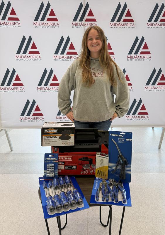 female student standing behind a small table with tools