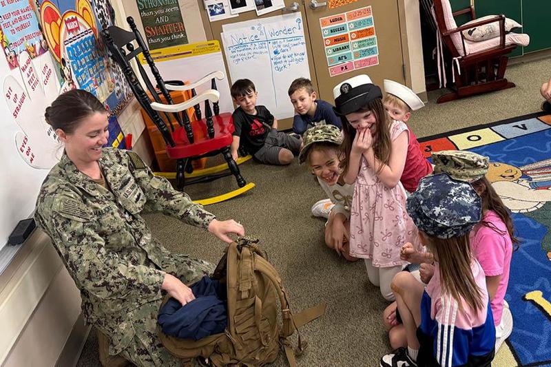 Katie Halicke shows the students in Mrs. Caruso’s class the different hats and uniforms she wore throughout her time with the Navy
