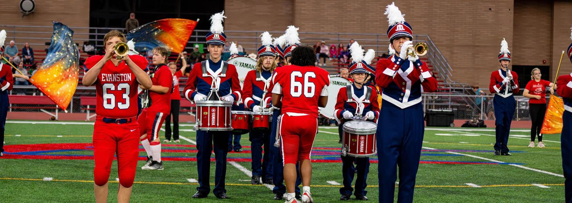 Marching band performing on the field during a colorful halftime show.