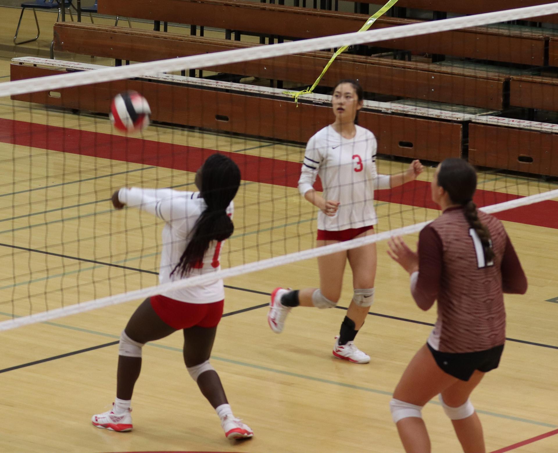varsity volleyball players in action against Fresno Christian