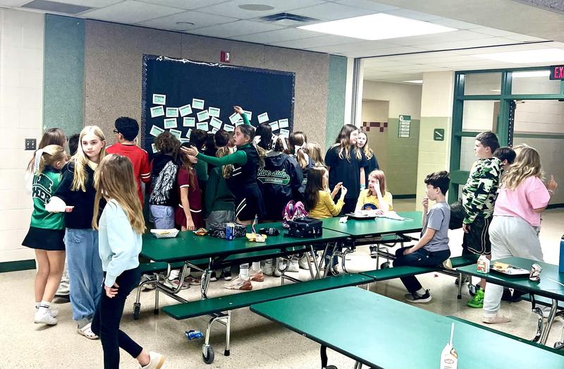 Our Riverside Middle School students gather around the bulletin board to see if they have received a ROAR Card. These special cards celebrate students who go above and beyond expectations. Featured Photo