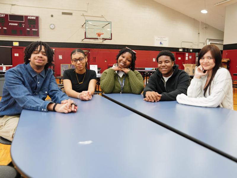 Five students sitting around a lunch table.