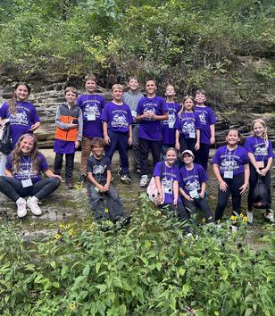Students standing on a rock formation at outdoor education