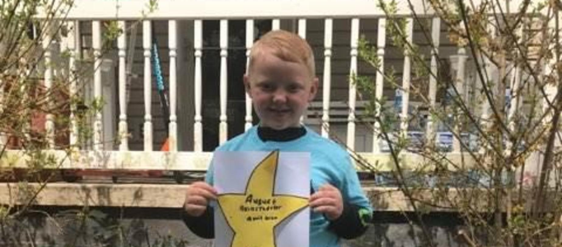 boy smiling for camera holding star