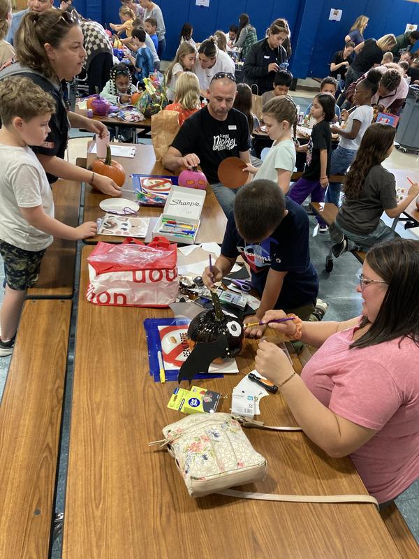 students and parents decorating pumpkins