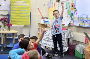 student raises hand in classroom