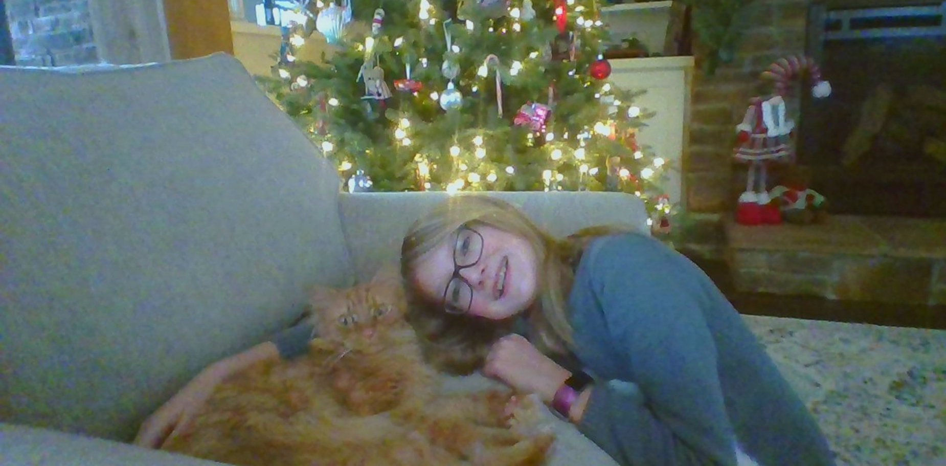 girl and her cat in front of a Christmas tree