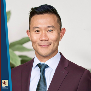 Dennis Yong, a man with dark hair in a burgundy suit smiling