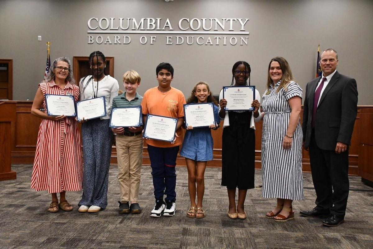 8 people holding 6 awards