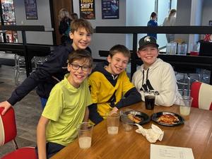 Four students seated together enjoying food.