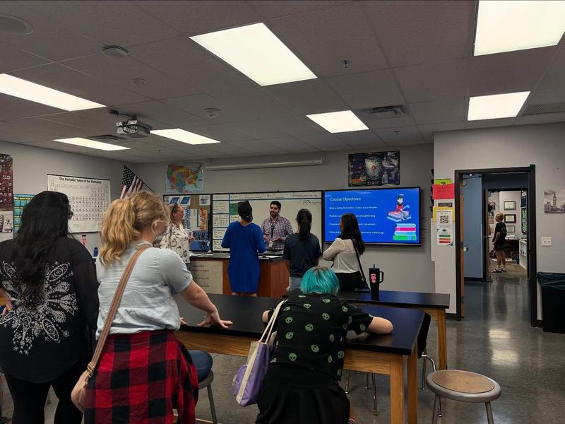 photo of parents & students listening to a teacher speak