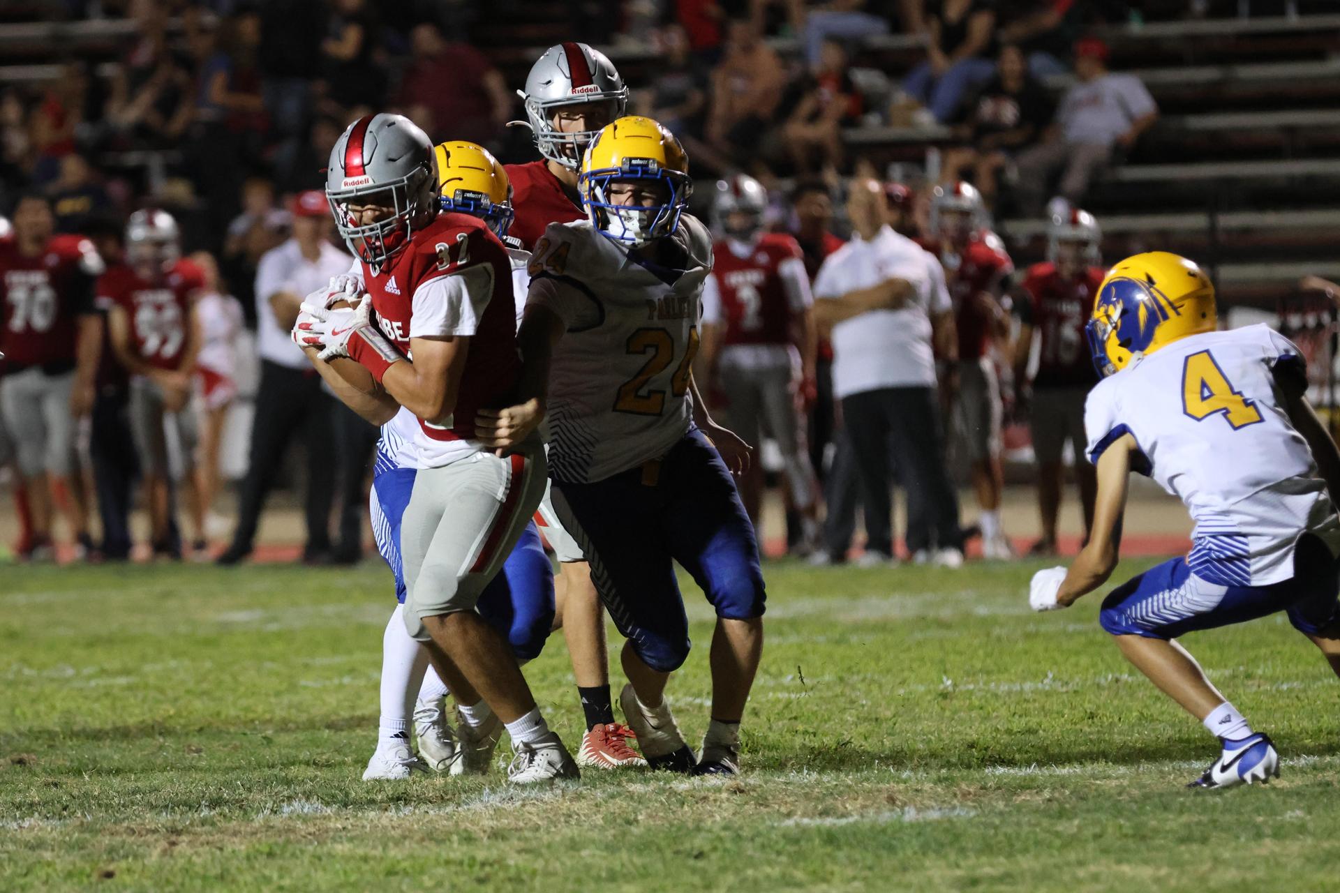 Varsity football players in action against Parlier 109
