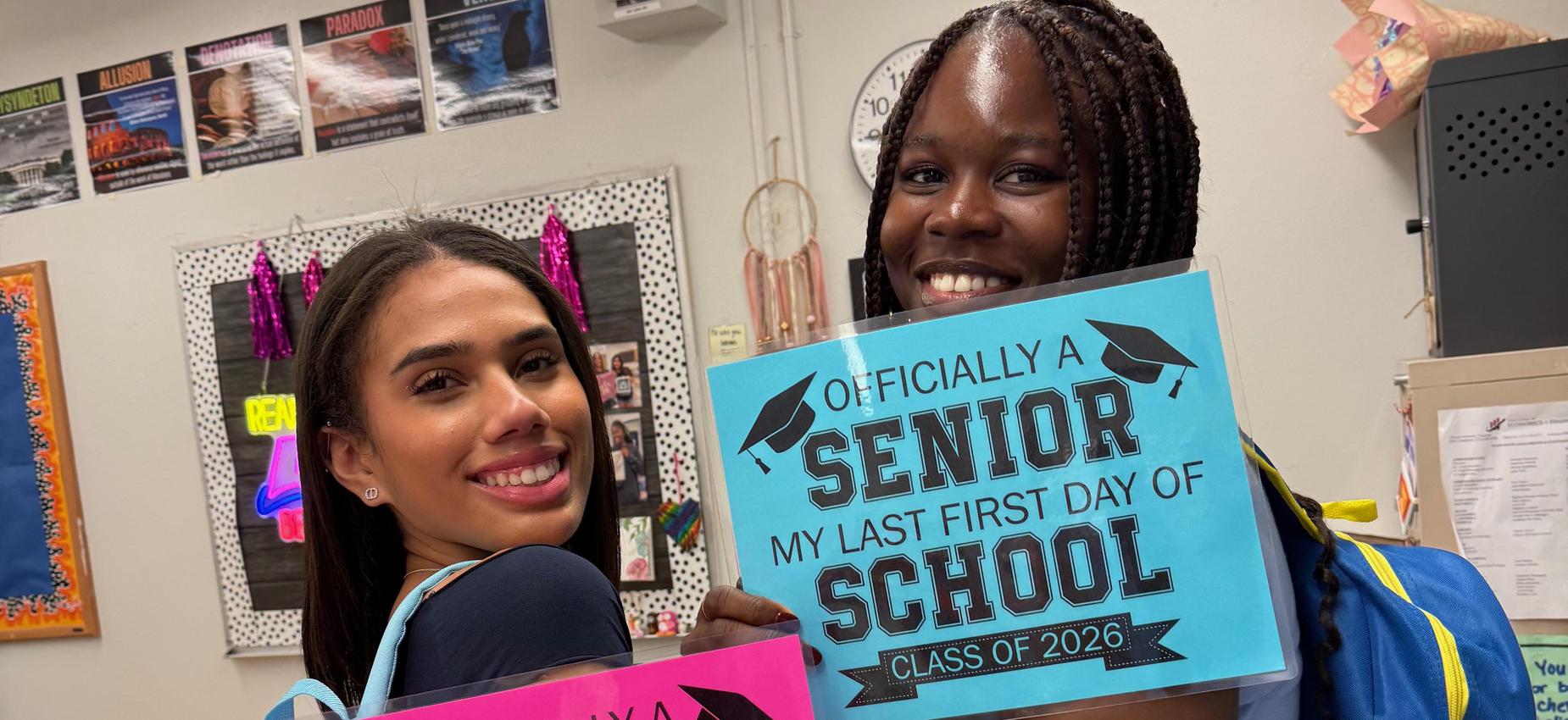 2 students holding "Officially a senior. My last day of school" signs