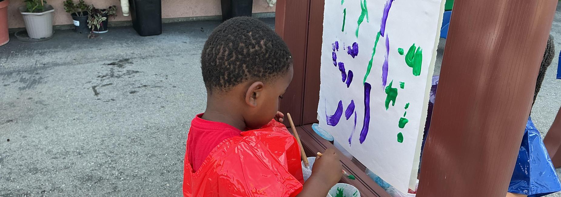 child painting during outdoor choice time