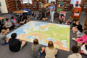 students gathered together for interactive lesson on map