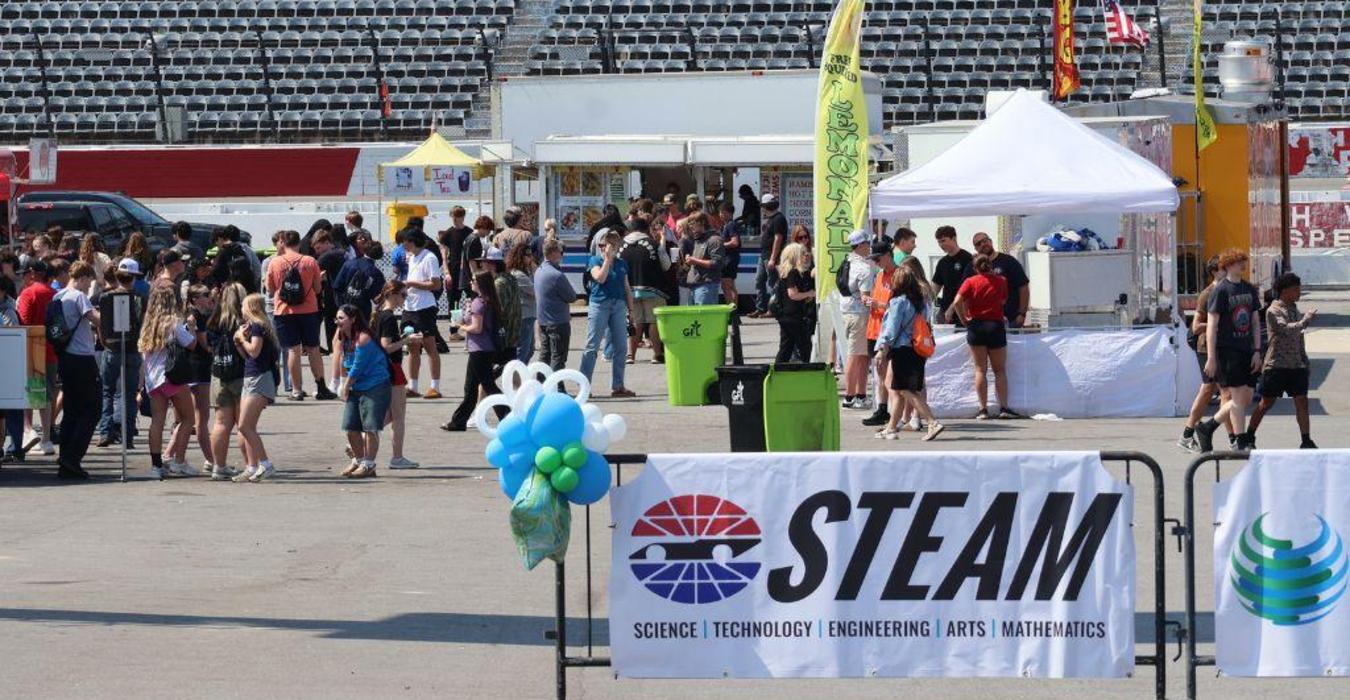 Crowd enjoying an outdoor festival with food stalls and vendor tents.