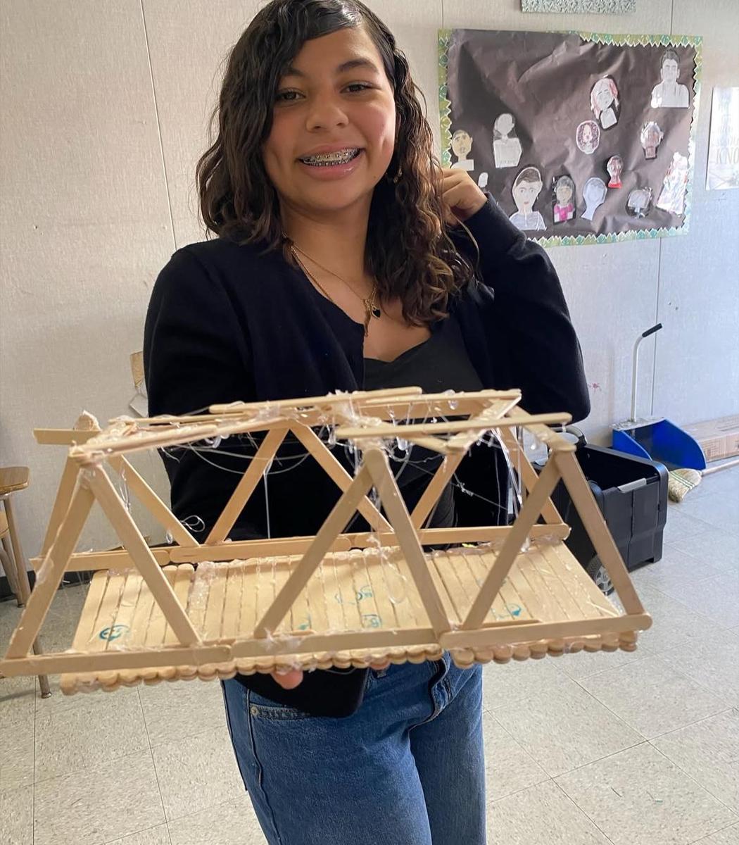 student with bridge made out of sticks