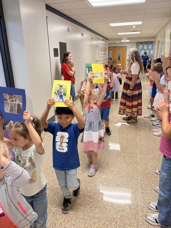 Students holding pictures of their pets