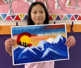 Student holding winning CO themed artwork