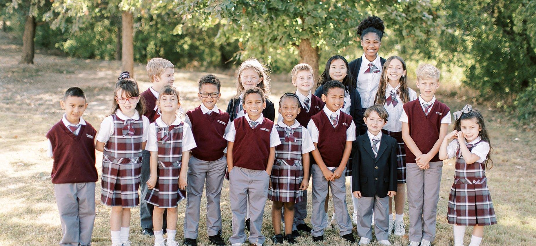 A class of Founders Classical Academy of Fort Worth students standing together outdoors with their teacher