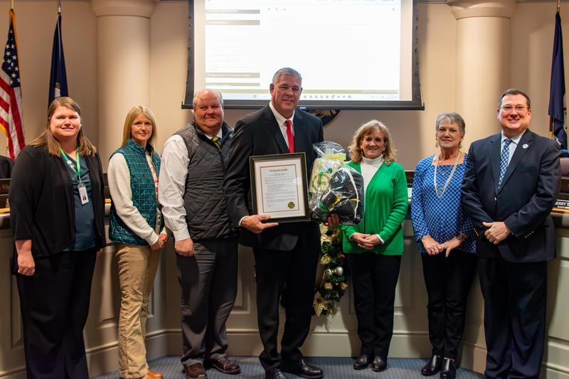 Prince George County School Board District 2 Member Christopher A. Johnson is honored with a resolution and PGCPS gift during his final meeting as a board member, joined by Deputy Superintendent Dr. Abbie Martin, board members Michelle Crist, Rob Eley, Sherry Taylor, Jill Andrews, and Division Superintendent Dr. Wayne Lyle.