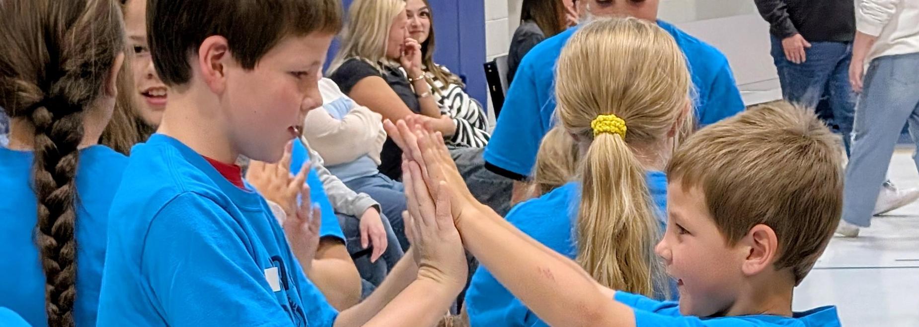 Students participating in an activity to connect during school assembly