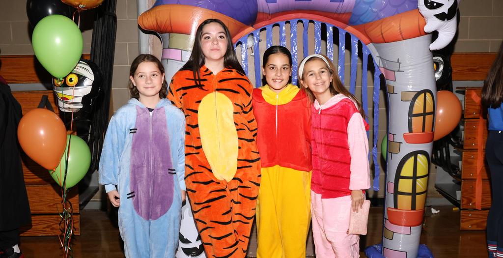Four girls dressed in Winnie the Pooh character costumes.