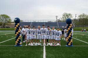 boys in lacrosse jerseys between two balloon columns