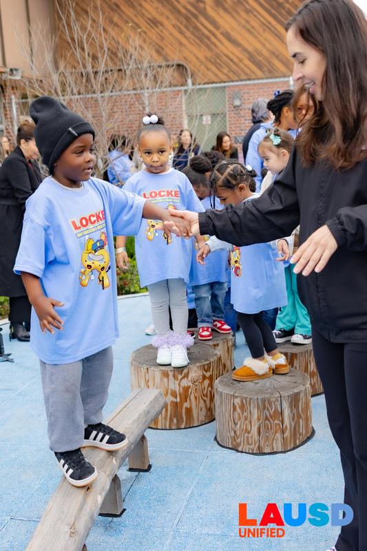 children with Board Member Franklin on balance beam