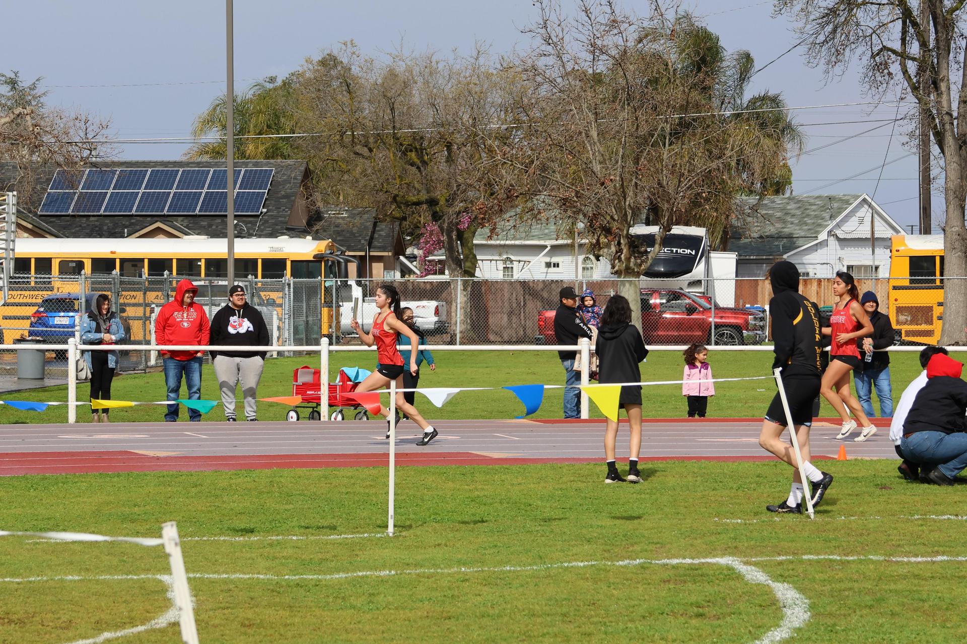 girls running the four by 100 meter relay