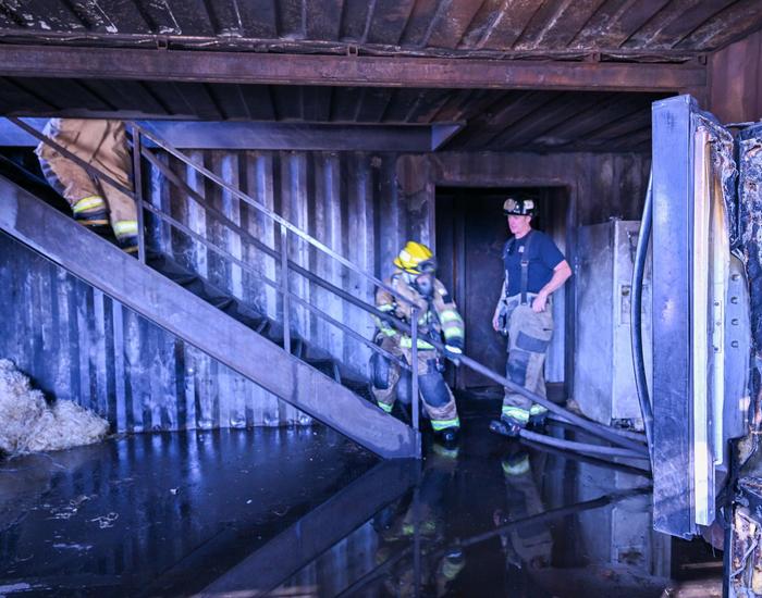 fire science students hauling fire hose upstairs